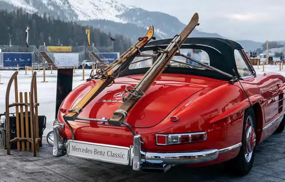 Roter Mercedes-Benz Classic Roadster mit historischen Skiern in St. Moritz